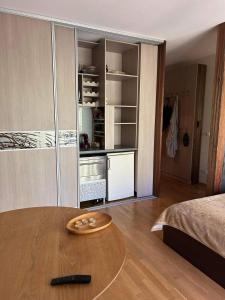 a living room with a table and a bedroom at Vanagupės 24 in Palanga
