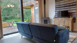 niebieską kanapę w salonie z dużym oknem w obiekcie Chez Rosé w mieście Sainte-Cécile