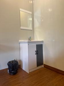 科欽的住宿－WHOOSH HOMES，一间设有白色橱柜和墙上镜子的房间