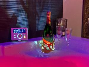 Una botella de vino sobre una mesa con copas. en L'Eden, en Saint-Rémy-lès-Chevreuse