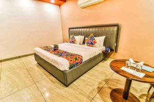 a bedroom with a bed and a table at OYO Home Service One Hopitality Near Appu Ghar in Gurgaon