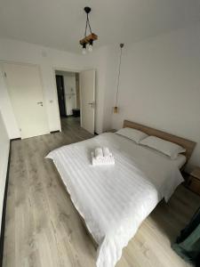 een slaapkamer met een wit bed en 2 handdoeken bij Boutique apartments 1 in Sînpetru