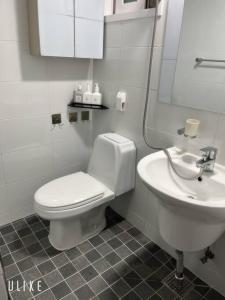 La salle de bains blanche est pourvue de toilettes et d'un lavabo. dans l'établissement Tolerance, à Incheon