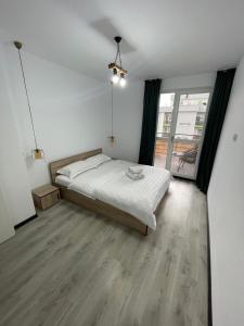 een slaapkamer met een bed en een groot raam bij Boutique apartments 1 in Sînpetru