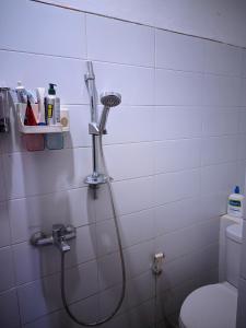 ein Bad mit einer Dusche mit einem Duschkopf in der Unterkunft K'Ajeng Cottage in Penebel