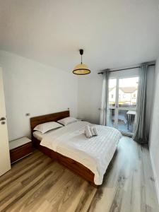 een slaapkamer met een groot bed en een groot raam bij Boutique Apartments 2 in Sînpetru