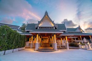 un grand bâtiment avec un toit pointu et des colonnes dans l'établissement Orchidacea Resort - Kata Beach, à Kata Beach