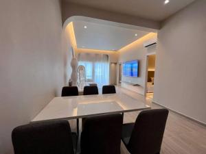 a dining room with a table and chairs and a television at Mountain View 506 in Kuah