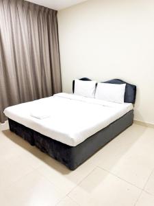 1 cama con sábanas blancas y almohadas en una habitación en Ras Star Residence - Home Stay, en Dubái