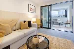 a living room with a couch and a table at In the heart of it all: 2 bed CBD townhouse in Christchurch