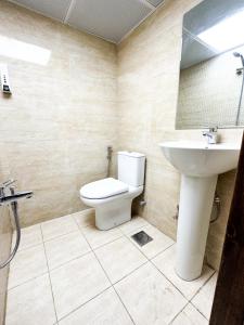 a bathroom with a toilet and a sink at Ras Star Residence - Home Stay in Dubai