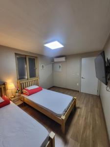1 dormitorio con 2 camas y TV de pantalla plana en Red Guesthouse, en Seúl
