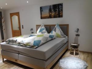 1 cama con almohadas coloridas en un dormitorio en Ferienwohnung Bayerwaldblick, en Jandelsbrunn