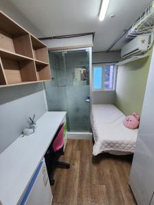 a small room with a bed and a desk at Gangnam Best Dormitory in Seoul