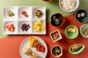 una mesa con platos de comida y cuencos de arroz en Hotel Vista Premio Kyoto Kawaramachi St, en Kioto