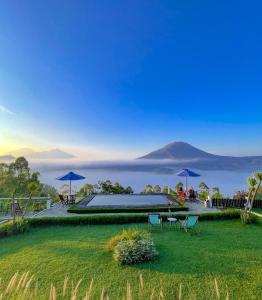 a house with a lawn with a view of a mountain at Pinggan caldera in Baturaja
