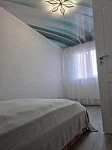 1 dormitorio con ventilador de techo y 1 cama en Apartament in zona centrala., en Hunedoara
