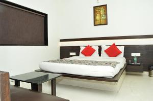 a bedroom with a bed with red pillows at HOTEL SUNIL INN in Raipur