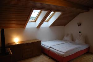 - une chambre avec un lit dans une pièce dotée de lucarnes dans l'établissement Apartmenthaus Maxl, à Bad Hofgastein