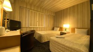 Habitación de hotel con 2 camas y escritorio en Hotel Select Inn Isehara en Isehara