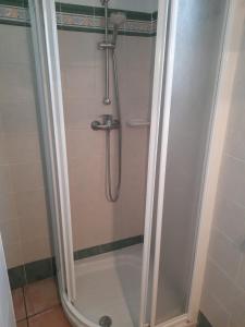 een douche met een glazen deur in de badkamer bij Casa Rosa in Alcalalí