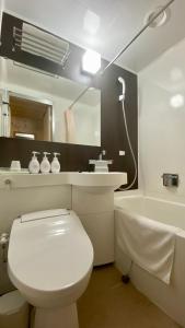 a bathroom with a toilet and a sink and a tub at Hotel Select Inn Isehara in Isehara