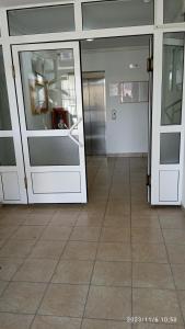 duas portas de vidro num edifício com piso de azulejo em Apartman Mira em Pozarevac
