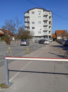 um parque de estacionamento com carros estacionados em frente a um edifício em Apartman Mira em Pozarevac