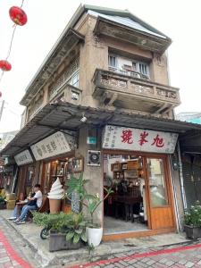 un edificio con persone sedute fuori da un ristorante di Long Lang Homestay a Tainan
