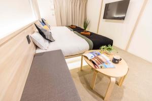 a bedroom with a bed and a table and a tv at Apartment Hotel 11 Kuromon in Osaka