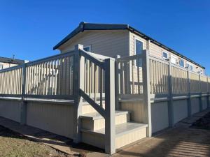 a house with a staircase leading up to it at 8 BERTH Deluxe caravan PALM GROVE 142 GOLDEN PALM CHAPEL ST LEONARDS in Chapel Saint Leonards