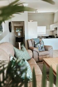 Sala de estar con 2 sofás y mesa en X7 -Goose Valley-Ocean Views, en Plettenberg Bay