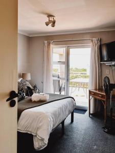 1 dormitorio con cama y ventana grande en X7 -Goose Valley-Ocean Views, en Plettenberg Bay