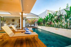 einen Pool in einer Villa mit Stühlen und einem Pool in der Unterkunft Villa Ryky - 2 Bedroom Private Luxury Villa in Nyanyi Beach in Tanah Lot + 21 Fotos
