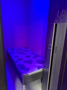 a bed in a room with purple and blue lights at Heavens Stay in Dubai