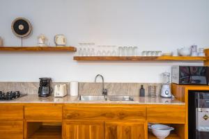 eine Küche mit Holzschränken und einer Spüle in der Unterkunft Villa Ryky - 2 Bedroom Private Luxury Villa in Nyanyi Beach in Tanah Lot