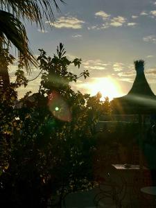 a sunset with a silhouette of a statue in the background at Riad Sable Chaud in Marrakesh