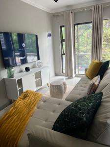 een woonkamer met een bank en een tv bij Serenity HideAway in Johannesburg
