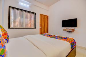 a bedroom with two beds and a flat screen tv at FabExpress Sky Inn in Pune