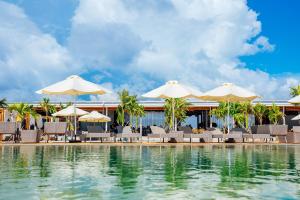 un complejo con piscina con sillas y sombrillas en Summer Bay Beach Club & Cabins en Sihanoukville