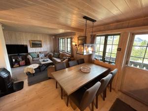 ein Wohnzimmer mit einem Holztisch und einem Sofa in der Unterkunft Cabin with a great view at Gaustablikk in Gaustablikk