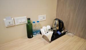 a counter with a bottle of water and a blender at Paras Studios By The Lodgers-Serviced Apartments Near Artemis Hospital Gurgaon in Gurgaon