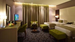 ジッダにあるHayat Heraa Hotelのベッド2台とテレビが備わるホテルルームです。