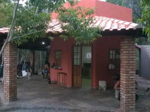 Camping Guapira في فالي دو كاباو: منزل احمر بسقف احمر