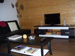 a living room with a tv and a coffee table at Vivienda de uso turístico Fuente Vilda VT-LR 0033 in Alcanadre