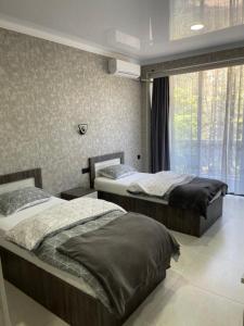 two beds in a bedroom with a window at House by the Sea in Kobuleti