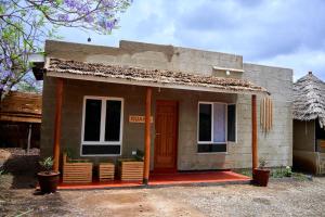 una pequeña casa con un porche rojo y una puerta en freedom inn, en Arusha