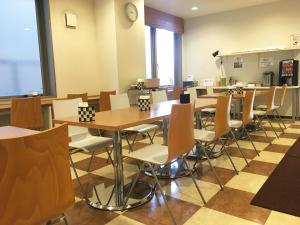 a dining room with tables and chairs and a clock at ホテルアイシス掛川 in Kakegawa
