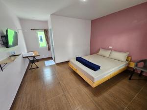 Klong Zand Resort في رايونغ: غرفة نوم بسرير ومكتب وتلفزيون