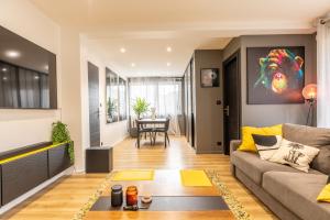 ein Wohnzimmer mit Sofa und Tisch in der Unterkunft F3 charmant neuf et équipé avec balcon "Wailly" in Clermont-Ferrand